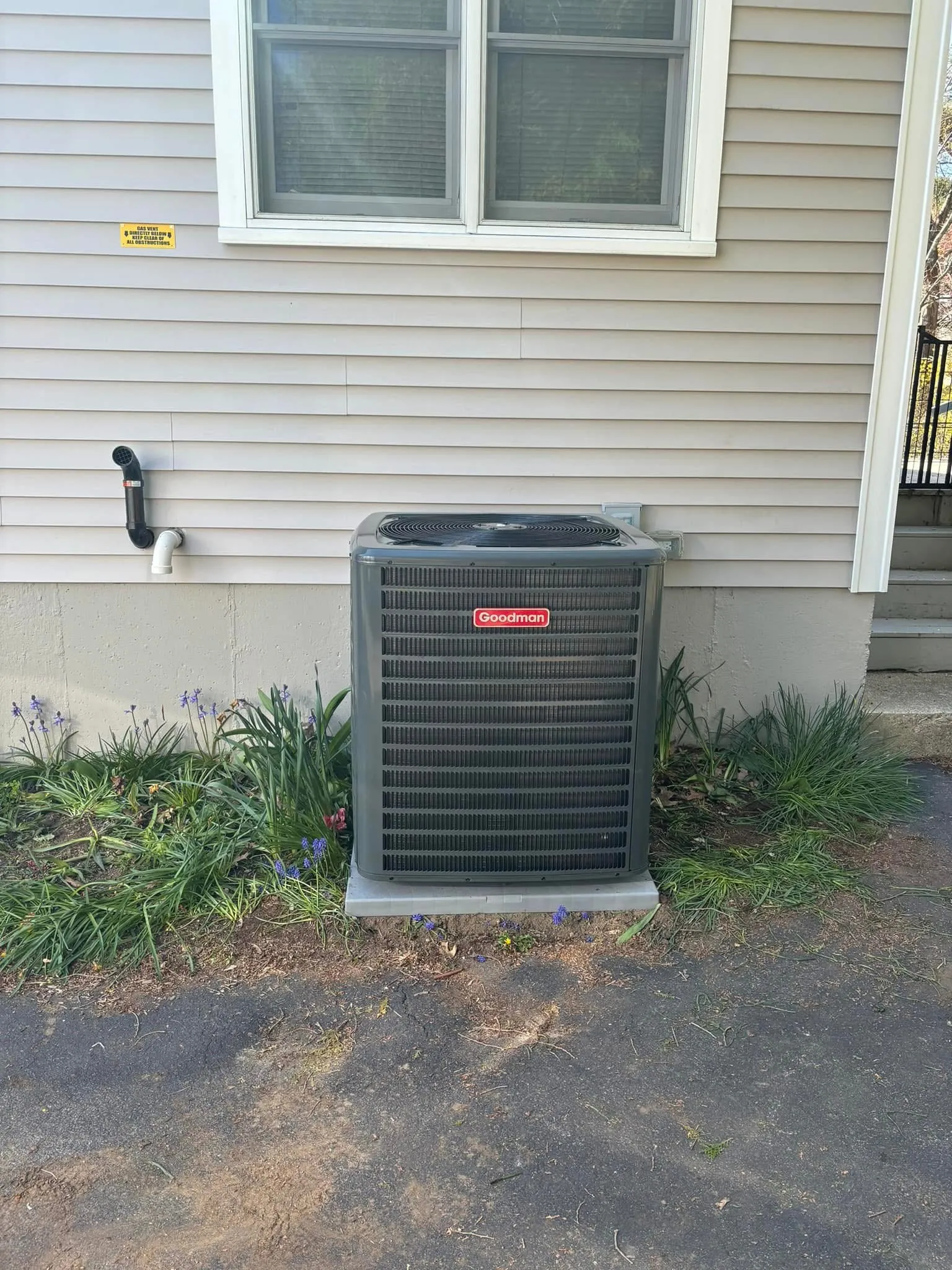 New Goodman AC condenser installed on a pad beside a MetroWest home