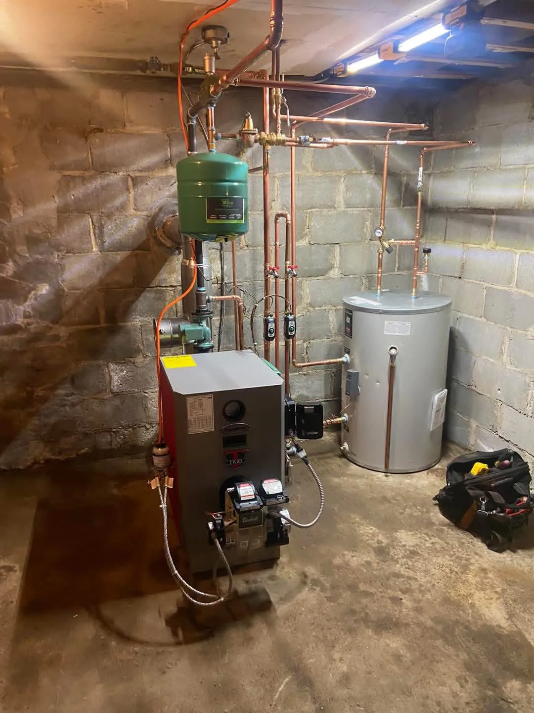 PurePro oil boiler with an indirect water heater tank in a stone-foundation basement