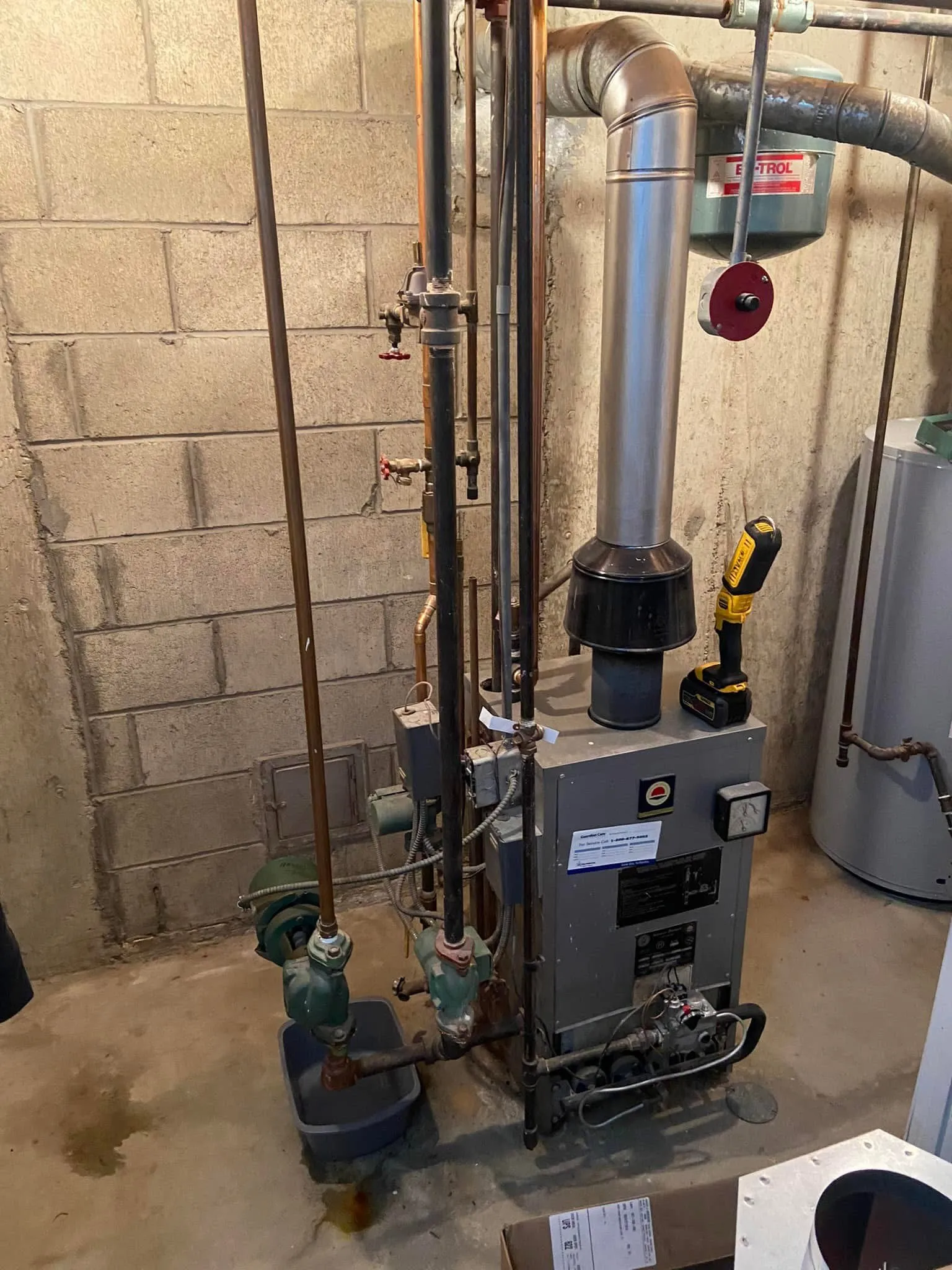 An older boiler mid-service on a Hannon call, work light in place