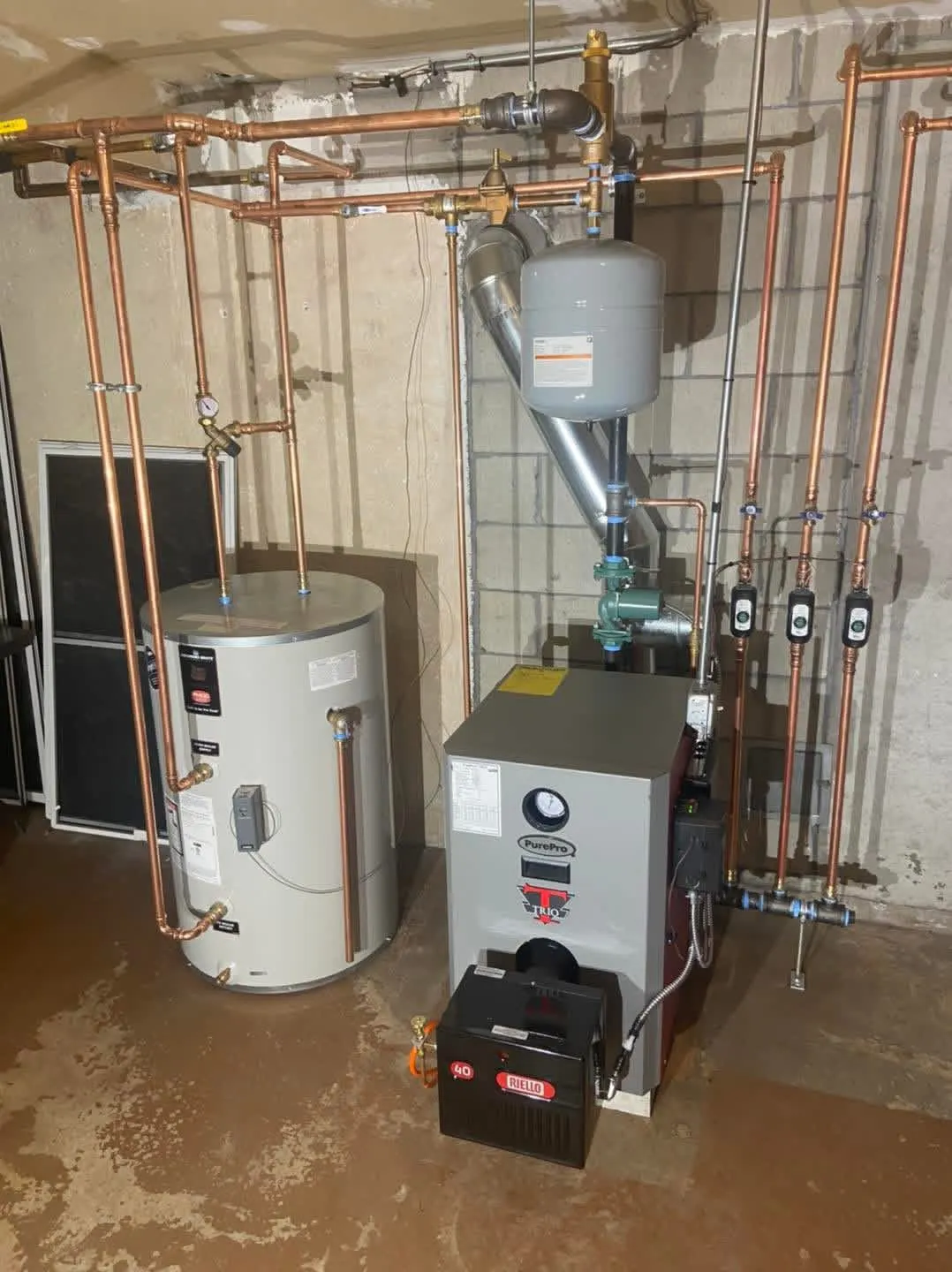 PurePro Trio boiler with neat copper piping and three green zone circulators in a zoned hydronic system