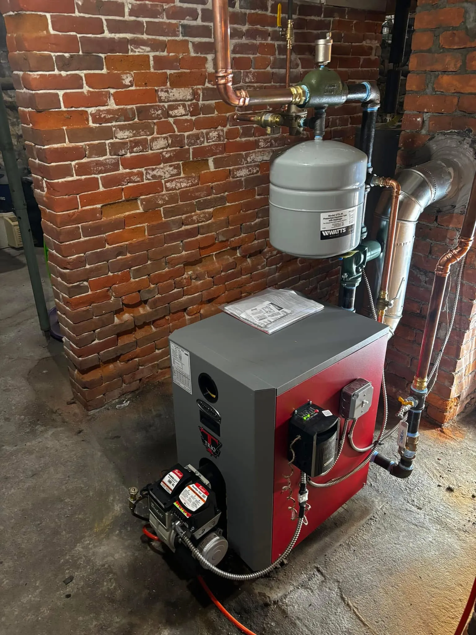 PurePro oil boiler with a Beckett burner against an exposed brick basement wall